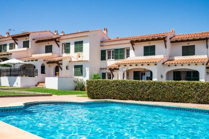 Casa adosada con piscina comunitaria y vistas al mar.